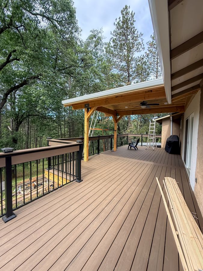 After: finished composite deck with timber-frame patio cover